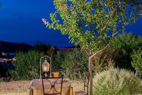 a table with a lantern next to a tree at Borgo Alba Barona Turismo Rurale in Golfo Aranci