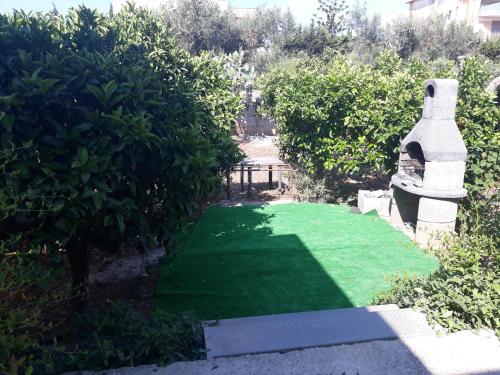 un patio con césped verde en un jardín en Appartamento da Anna, en Porto Cesareo