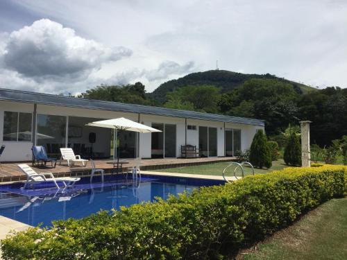 a house with a swimming pool and an umbrella at Finca La Ranchera No. 2 in Tarso