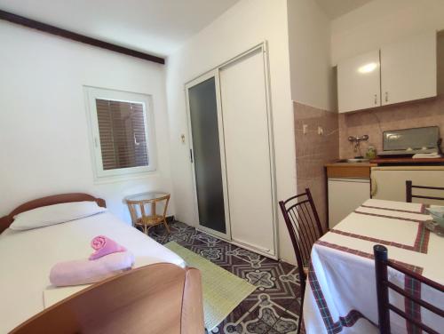 um pequeno quarto com 2 camas e uma cozinha em Apartmani Djedovic 2 em Petrovac na Moru