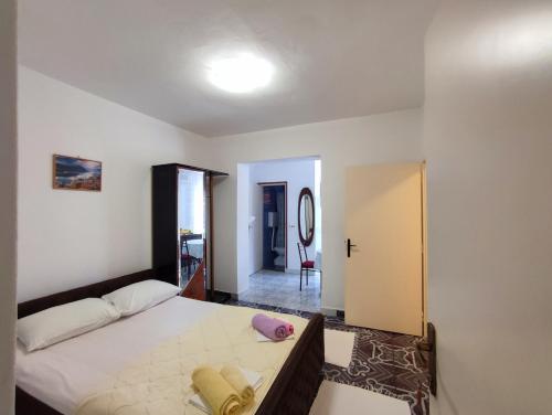 - une chambre avec un grand lit et un couloir dans l'établissement Apartmani Djedovic 2, à Petrovac na Moru