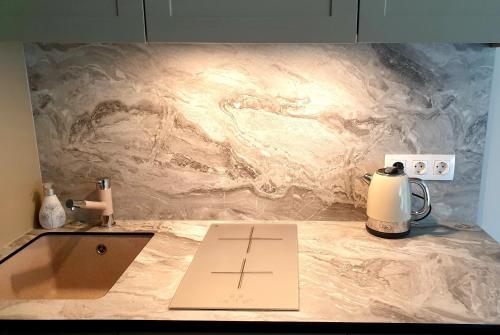 a marble counter top with a tea kettle on it at Orange Studio in Juodkrantė