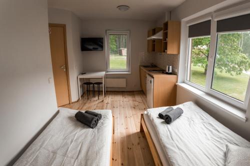 two beds in a small room with a kitchen at Camping & Camper place Pasvalys in Pasvalys