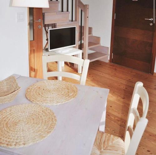 een witte tafel met 2 stoelen en een bureau met een computer bij La Casa Griunit in Capriva del Friuli