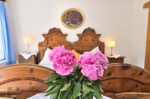 un vaso di fiori rosa seduto su un tavolo di Gasthof Simony Hallstatt B&B a Hallstatt