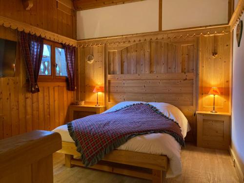une chambre avec un lit et deux lampes dedans dans l'établissement Le Battieu, à Samoëns