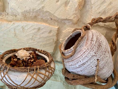 two baskets with a flower in them next to a wall at HABITARE Lecce & Salento in Lecce