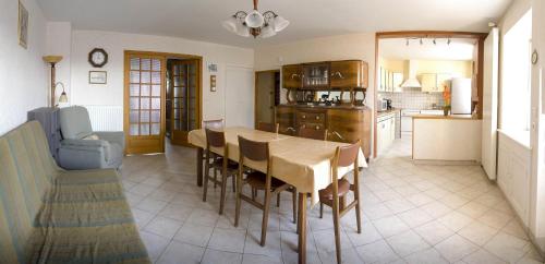 eine Küche und ein Esszimmer mit einem Tisch und Stühlen in der Unterkunft Le loup qui dort in Longwy-sur-le-Doubs