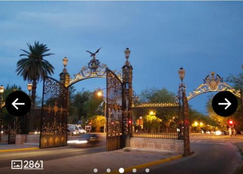an ornate gate in a city at night at Excelente Apartamento, a metros del Parque San Martín! in Mendoza