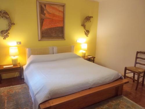 ArcugnanoにあるCa' del Vento B&Bのベッドルーム1室(白いベッド1台、椅子2脚付)