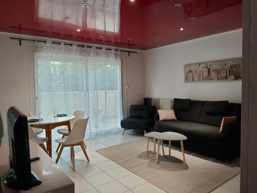a living room with a couch and a table at Joli studio les pieds dans l eau avec place de Parking gratuite in Bandol