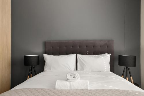 a bed with a towel on it with two lamps at Easy Stay - The Vantage Rosebank in Johannesburg