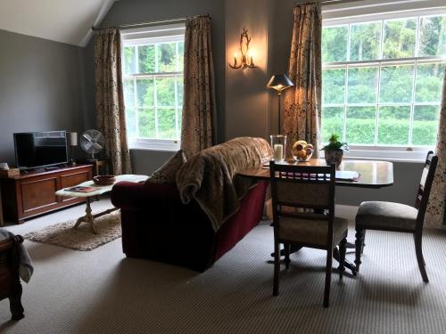 The Cheese Room, self-contained cosy retreat in the Quantock Hills في بريدجواتر: غرفة معيشة مع أريكة وطاولة
