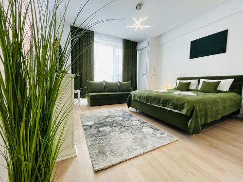 - une chambre avec un lit vert et un canapé dans l'établissement Evo onix mamaia nord, à Mamaia Nord – Năvodari
