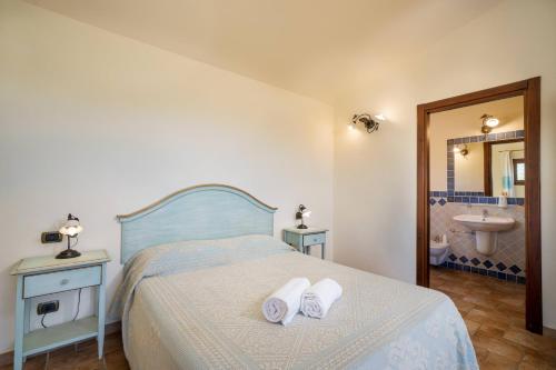a bedroom with a bed with two towels on it at Borgo Alba Barona Turismo Rurale in Golfo Aranci