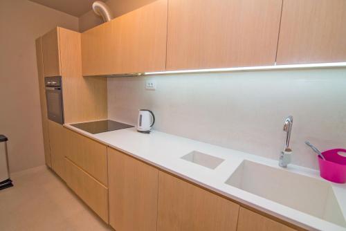 a kitchen with wooden cabinets and a sink at Jelena B4 in Veli Lošinj