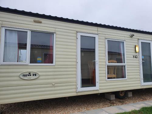 a beige trailer with windows on the side of it at 6 Berth Caravan The Grange Ingoldmells in Skegness