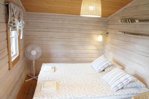 a bedroom with a bed in a wooden room at Wästinn in Vöyri
