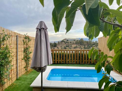 an umbrella sitting next to a swimming pool at Suite Breeze - Private Heated Pool in Málaga