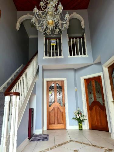 a hallway with two wooden doors and a chandelier at Archmor house B&B in Knock