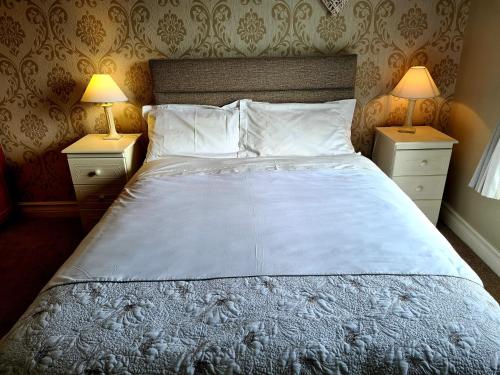 1 dormitorio con 1 cama grande y 2 mesitas de noche en Archmor house B&B, en Knock