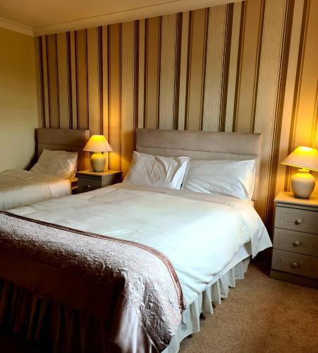 a bedroom with two beds and two lamps on tables at Archmor house B&B in Knock