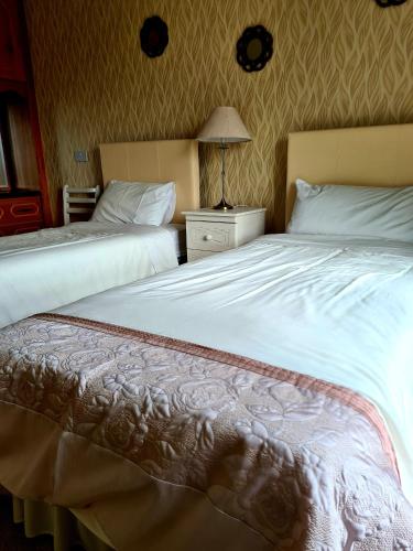 dos camas sentadas una al lado de la otra en una habitación de hotel en Archmor house B&B, en Knock