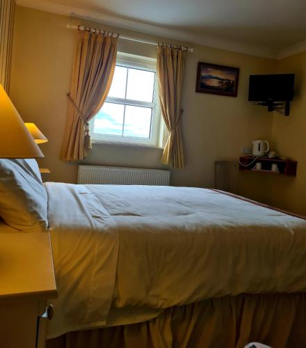 Un dormitorio con una cama grande y una ventana en Archmor house B&B, en Knock