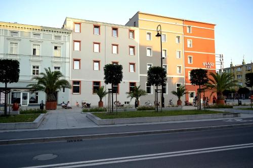 una calle de la ciudad con edificios y palmeras frente a una carretera en Hotel Piast en Nysa