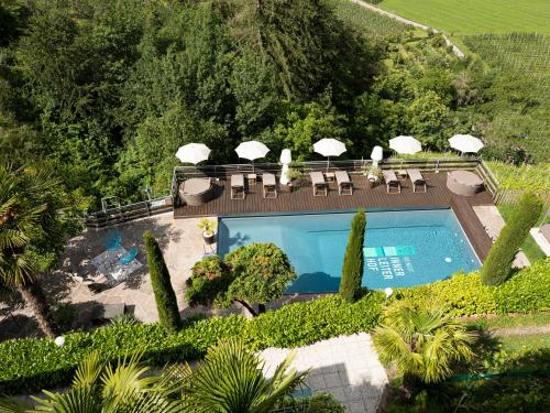 an aerial view of a swimming pool with chairs and umbrellas at Hotel Weingut Innerleiterhof in Schenna