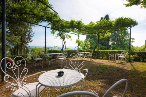 a table and chairs in a garden with a view at Villa Scacciapensieri Boutique Hotel in Siena