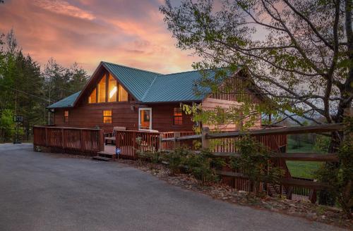 a cabin in the woods with a fence at BareFoot Cabin cabin in Sevierville
