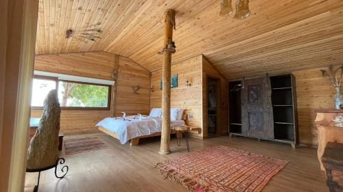 um quarto com uma cama num chalé de madeira em Olive Garden Kabak em Faralya