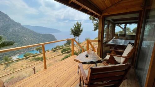 a balcony of a house with a table and chairs at Olive Garden Kabak in Faralya