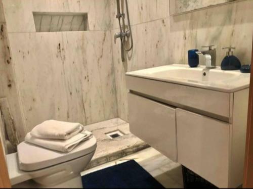 a white bathroom with a sink and a toilet at Maarif in Casablanca