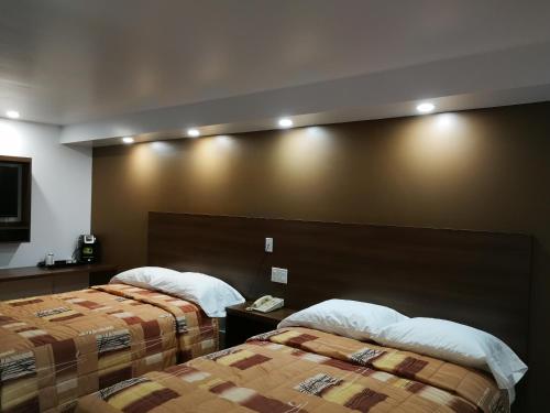 a hotel room with two beds and a wall with lights at Motel Chez Nous in Laval