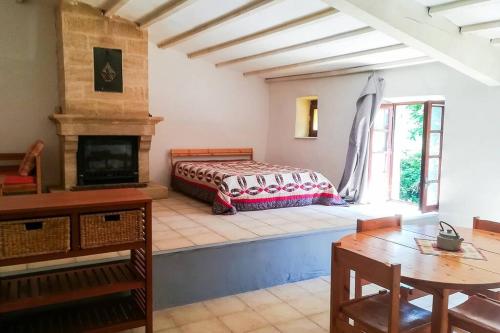 une chambre avec un lit et une cheminée dans l'établissement Mas provençal isolé en pleine nature, à Montjoyer