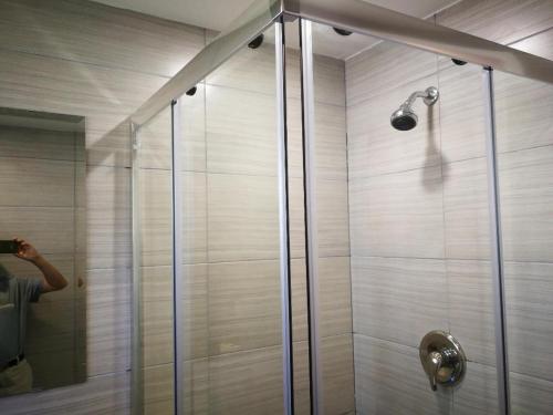 a shower with a glass door and a person taking a picture at Motel Chez Nous in Laval