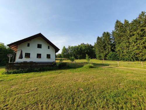 a white house in the middle of a field at Ferienhaus am Dachsberg, Bayerischer Wald in Haselbach