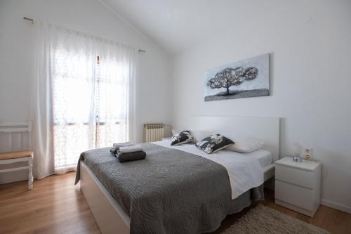 ein Schlafzimmer mit einem Bett und einem Baum an der Wand in der Unterkunft Apartments Onorina in Zadar