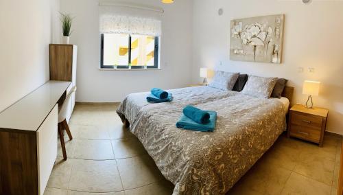 a bedroom with a bed with a blue towel on it at George's Quinta das Palmeiras, a 2 bedroom apartment in luxury complex, walking distance to town in Lagos