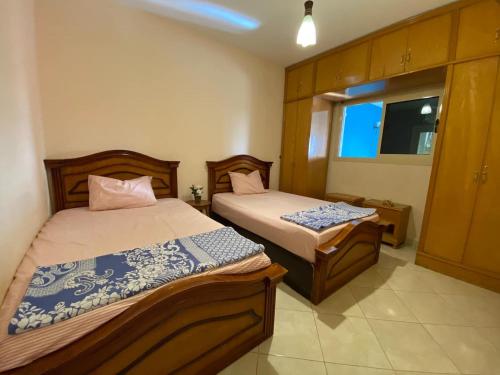 a bedroom with two beds and a window at Chalet with backyard in North Coast near Marina & New Alamein الساحل الشمالي العلمين in El Alamein