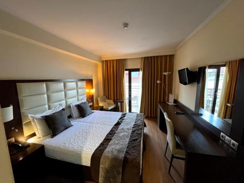 a hotel room with a large bed and a desk at Europa Hotel in Kastoria