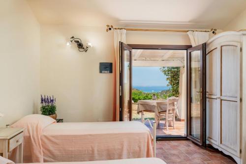 a room with two beds and a door to a patio at Borgo Alba Barona Turismo Rurale in Golfo Aranci