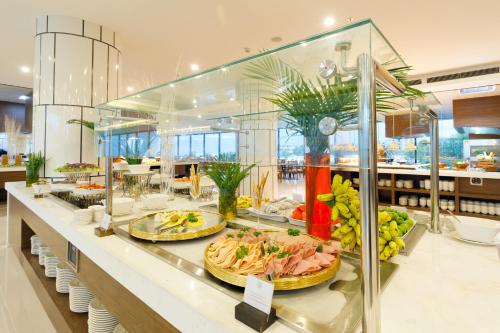 a buffet line with plates of food on display at Selectum Noa Resort Cam Ranh in Cam Ranh