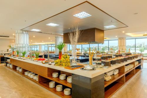 a buffet line with food on display in a restaurant at Selectum Noa Resort Cam Ranh in Cam Ranh