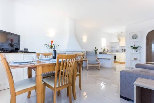 a kitchen and living room with a table and chairs at Apartamento Salema 33 in Salema