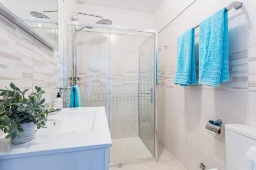 y baño con ducha acristalada y lavamanos. en Apartamento Salema 33 en Salema