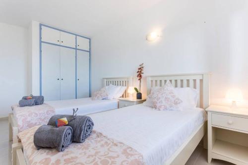 a bedroom with two beds with towels on them at Apartamento Salema 33 in Salema