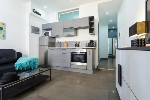 un salon avec un canapé et une cuisine dans l'établissement FEEL HOME - FRANCE 15, à Nice